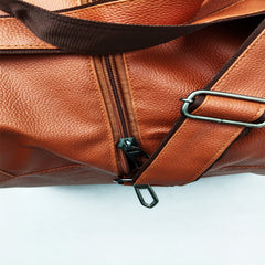 A full shot of a medium-sized, light brown duffel bag.