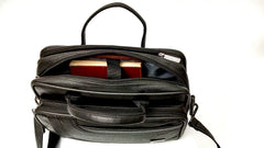 A black leather messenger bag sits